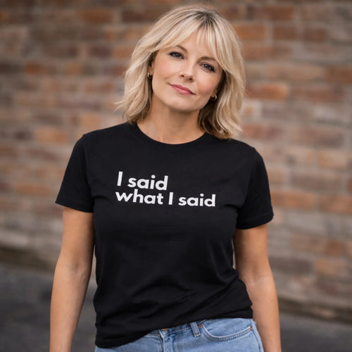 Black “I said what I said” t-shirt worn by UK woman outdoors against brick wall