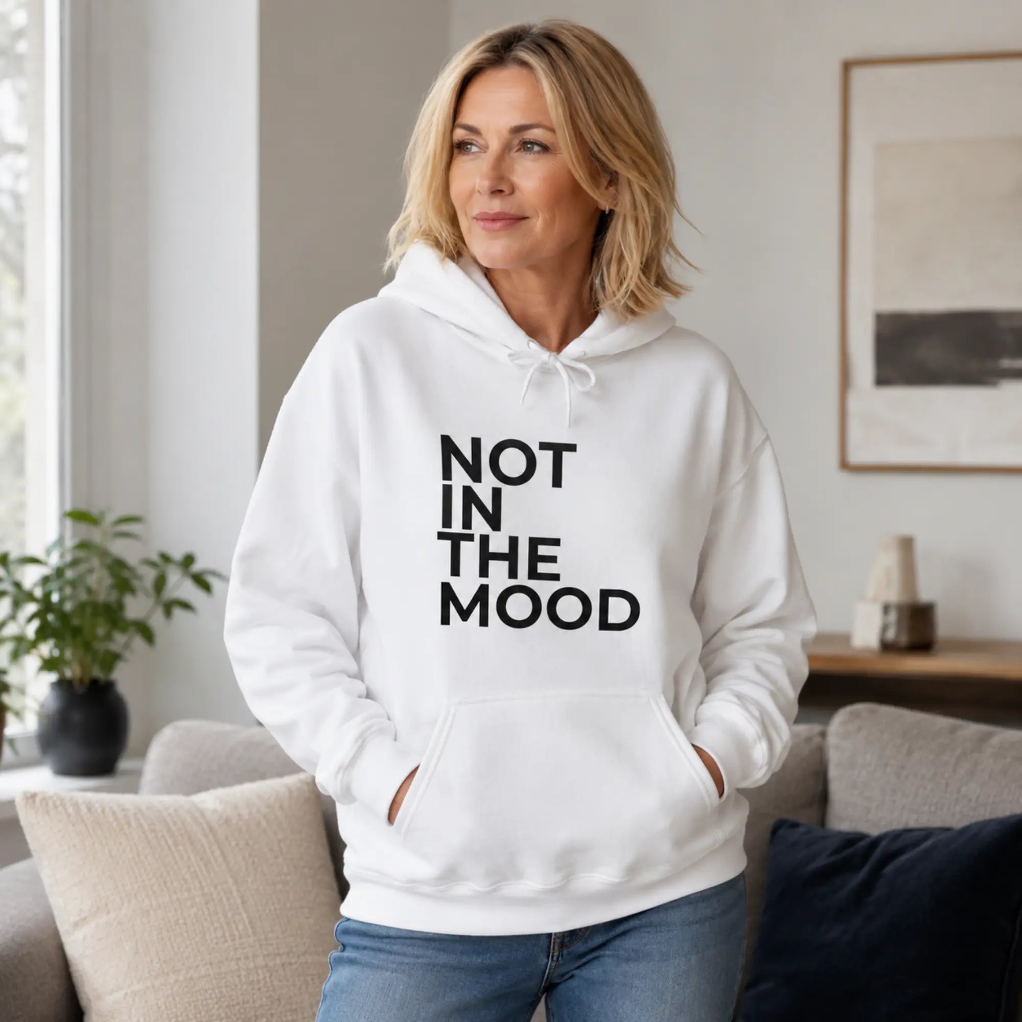 Woman wearing Not In The Mood white slogan hoodie in a stylish café